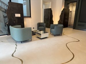 Réaménagement d'un hall d'accueil: inserts laiton dans le sol + signalétique retro éclairé en acier patiné