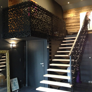 Escalier limon central et garde corps en panneaux à motifs decoratifs